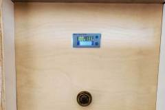 Battery compartment cover with a meter that shows current...