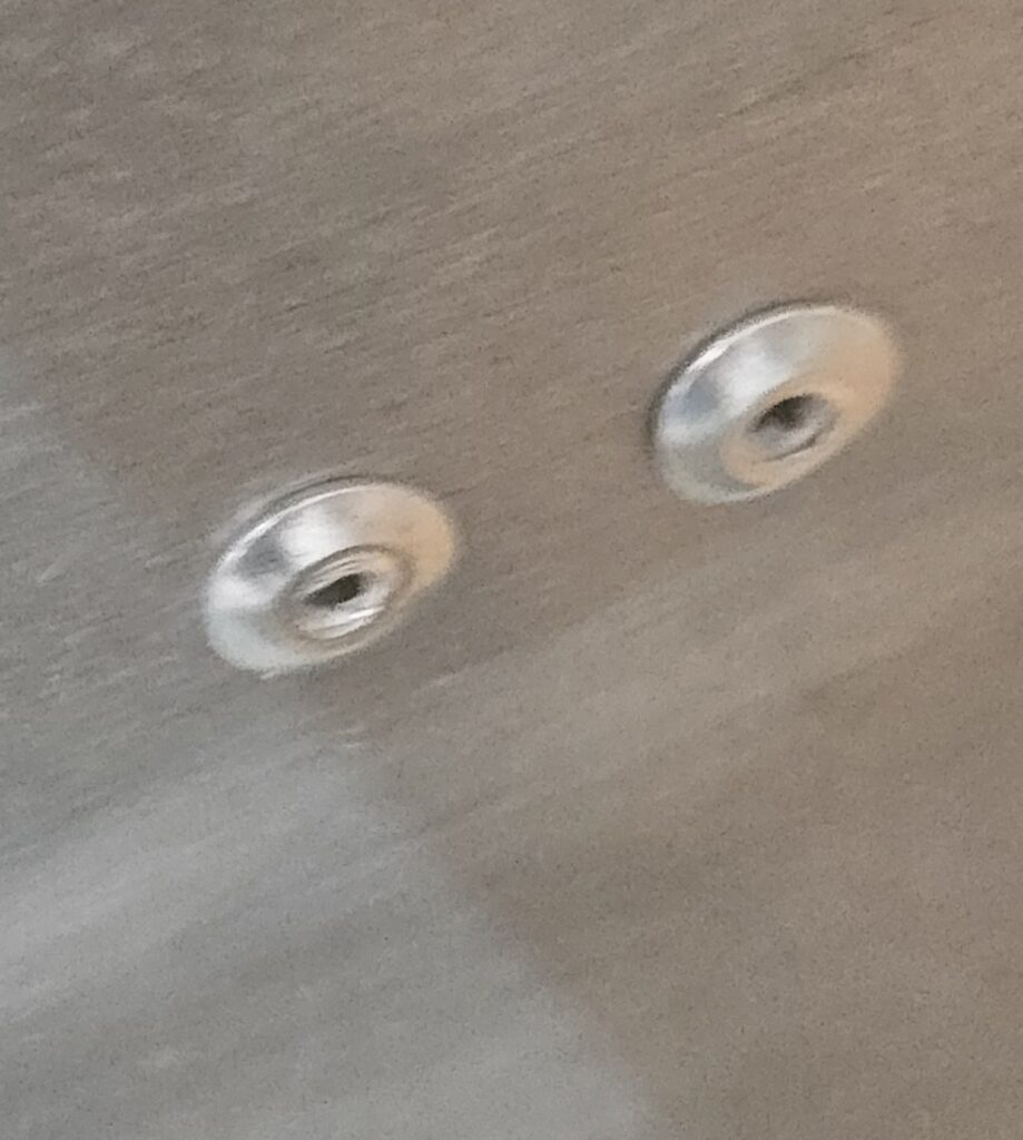 Pop Rivets heads face the window on the Rock Guard